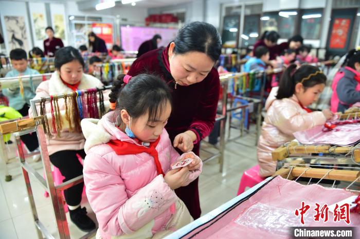 江西省級(jí)非遺豫章繡傳承人手把手指導(dǎo)小學(xué)生繡制2022年北京冬奧會(huì)吉祥物“冰墩墩”形象?！∮髟屏?攝
