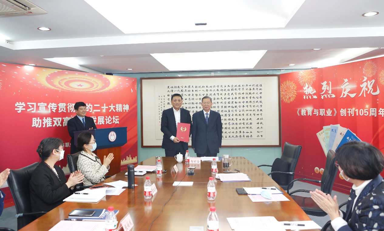 郝明金為《教育與職業(yè)》雜志編委代表陳曉明頒發(fā)聘書(shū)。中華職教社供圖