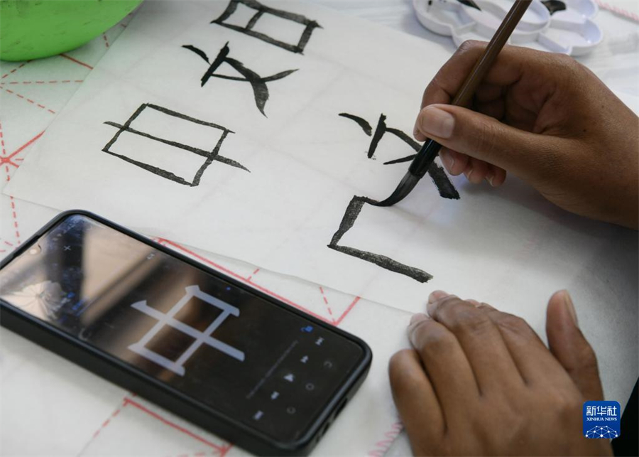 4月18日，肯尼亞學(xué)生在內(nèi)羅畢大學(xué)孔子學(xué)院舉辦的活動上寫毛筆字?？夏醽唭?nèi)羅畢大學(xué)孔子學(xué)院18日舉辦“中文，增進(jìn)文明對話”主題活動，慶祝即將到來的第14個聯(lián)合國中文日?？夏醽唽W(xué)生參與互動，進(jìn)行書法、剪紙、唱中文歌等活動。新華社記者 韓旭 攝