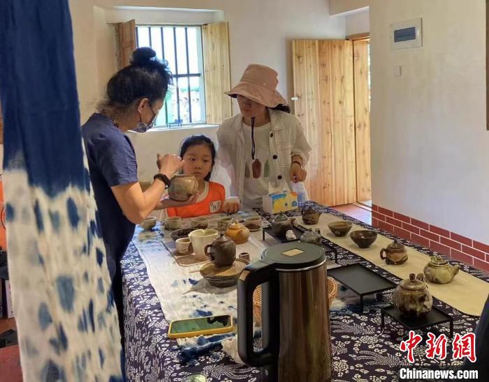 圖為：游客正在咨詢臺灣柴燒作品?！∪~秋云 攝