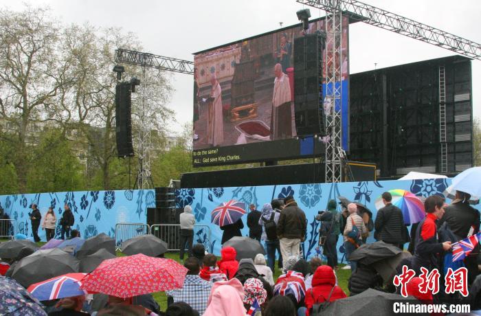 當(dāng)?shù)貢r(shí)間5月6日，英國(guó)國(guó)王查爾斯三世的加冕儀式舉行。民眾雨中觀看儀式。　歐陽(yáng)開(kāi)宇 攝