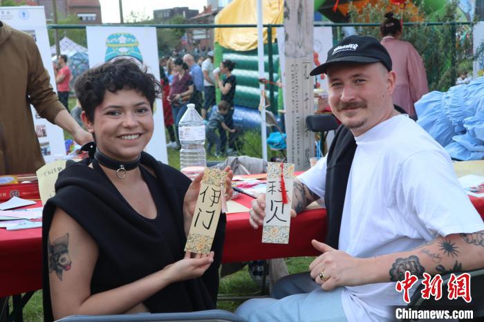 當(dāng)?shù)孛癖娫跐h字體驗(yàn)工作坊展示自己手寫的中文名書簽?！◆斻肟鬃訉W(xué)院供圖