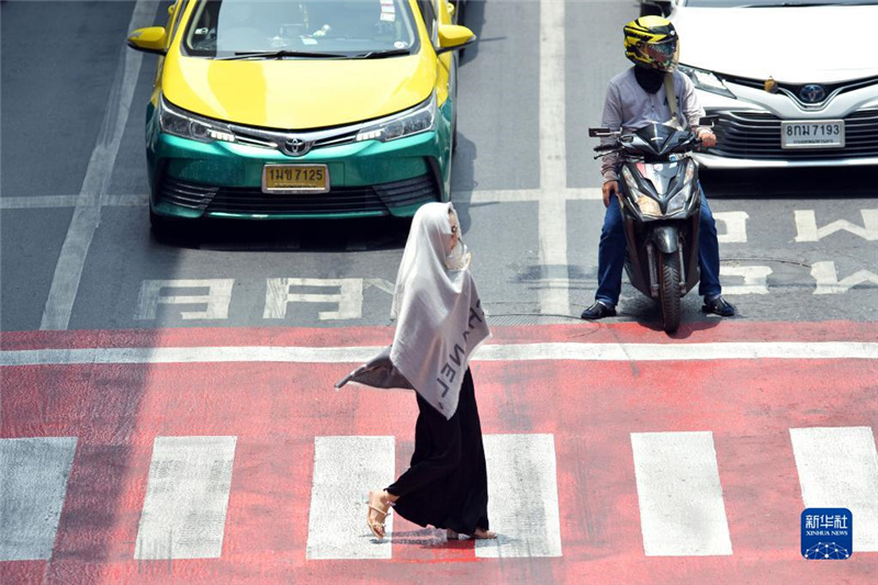 5月17日，行人在泰國(guó)曼谷街頭用圍巾遮陽(yáng)。新華社發(fā)（拉亨攝）