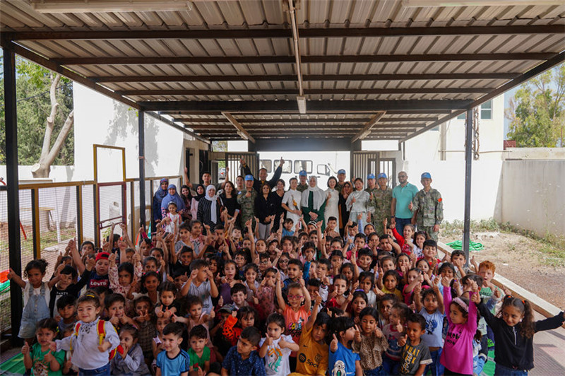 當(dāng)?shù)貢r(shí)間5月30日，黎巴嫩南部庫(kù)雷拉公立小學(xué)，“六一”國(guó)際兒童節(jié)前夕，中國(guó)第21批赴黎維和多功能工兵分隊(duì)官兵看望慰問(wèn)學(xué)校師生，并開(kāi)展文化交流活動(dòng)，圖為我維和官兵同師生合影。李竹林?jǐn)z