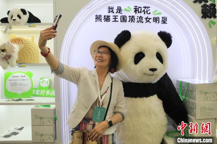 美國華視總裁楊蓮花與大熊貓文創(chuàng)產(chǎn)品合影?！⊥趵?攝