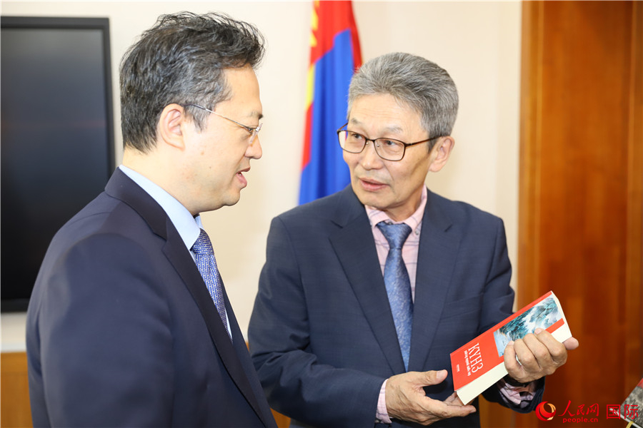 其米德策耶（右一）向李峙介紹翻譯成果。人民網(wǎng)記者 霍文攝