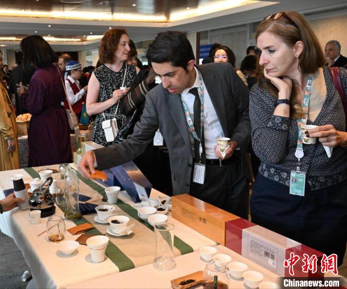 現場觀眾觀看中國展臺茶藝表演、了解茶文化?！【笜?攝