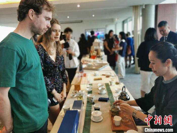 現場觀眾觀看中國展臺茶藝表演、了解茶文化。　靖樹 攝