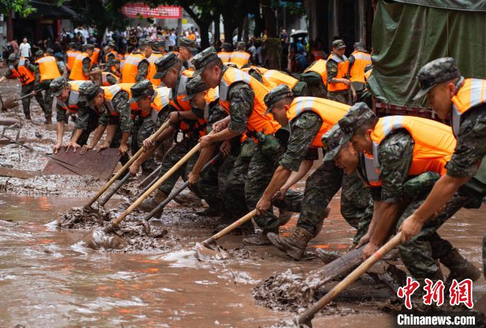 7月4日，萬州區(qū)五橋街道，武警官兵清理街道上的淤泥。　冉孟軍 攝