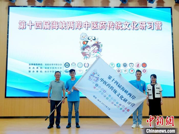 共青團(tuán)福建省委副書記吳雪(右一)、福建中醫(yī)藥大學(xué)黨委副書記林羽(左一)為兩岸學(xué)生代表頒授營旗。　許燁婷 攝