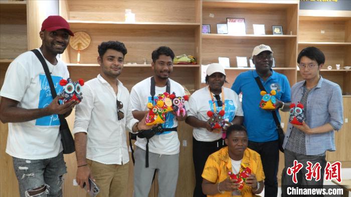 圖為國際青年代表展示親手制作的東營(yíng)非遺黃河口布偶 ?！↓R魯 攝