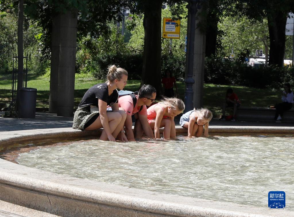 7月8日，人們在德國法蘭克福的一處噴泉玩水。近日，德國法蘭克福逐漸迎來暑熱天氣。新華社記者 張帆 攝