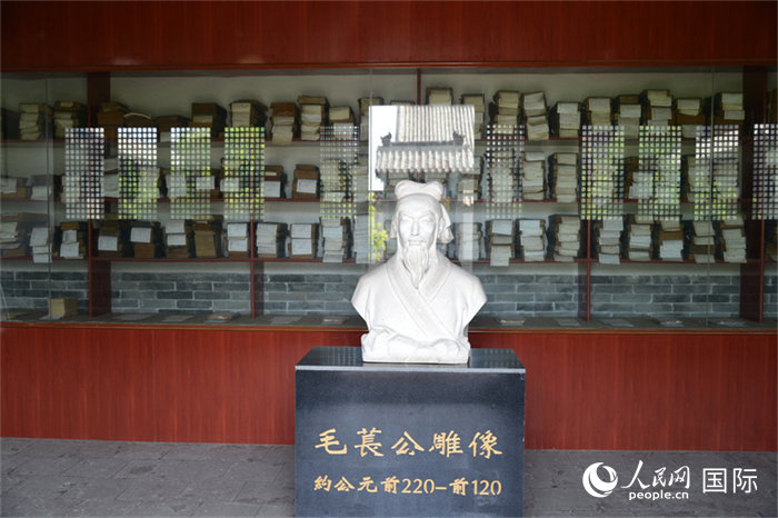 河間詩(shī)經(jīng)齋毛萇雕像。雕像后書(shū)櫥中陳列的是歷代各版本《詩(shī)經(jīng)》及譯本。 人民網(wǎng) 趙昭攝