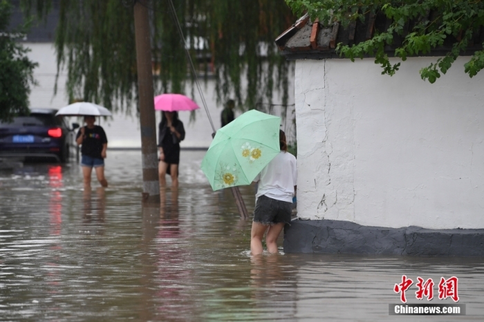7月31日，市民行走在雨中的北京房山區(qū)瓦窯頭村。北京市氣象臺當日10時發(fā)布分區(qū)域暴雨紅色預警信號。北京市水文總站發(fā)布洪水紅色預警，預計當日12時至14時，房山區(qū)大石河流域?qū)⒊霈F(xiàn)紅色預警標準洪水。<a target='_blank' href='/'><p  align=