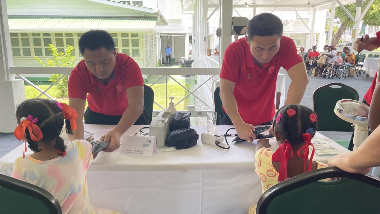 醫(yī)療隊(duì)員為福利院兒童進(jìn)行檢查。第18期援圭亞那醫(yī)療隊(duì)供圖