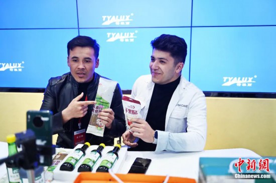 2023年3月，甘肅省慶陽市環(huán)縣電商創(chuàng)業(yè)孵化基地內(nèi)，來自蘭州文理學(xué)院的塔吉克斯坦留學(xué)生正在協(xié)助主播直播帶貨當?shù)剞r(nóng)特產(chǎn)品。李亞龍 攝