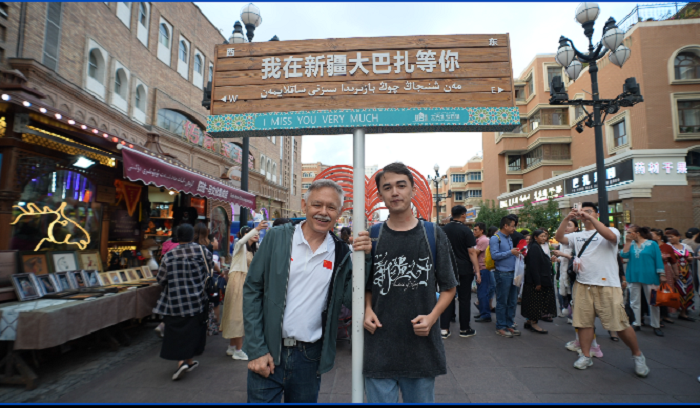 潘維廉和維吾爾族青年伊木蘭“打卡”大巴扎。主辦方供圖