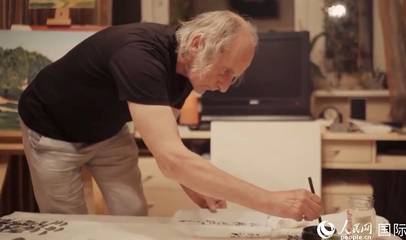 伊戈爾·布爾東諾夫在畫作上題詞。人民網(wǎng)記者 馬天翼攝