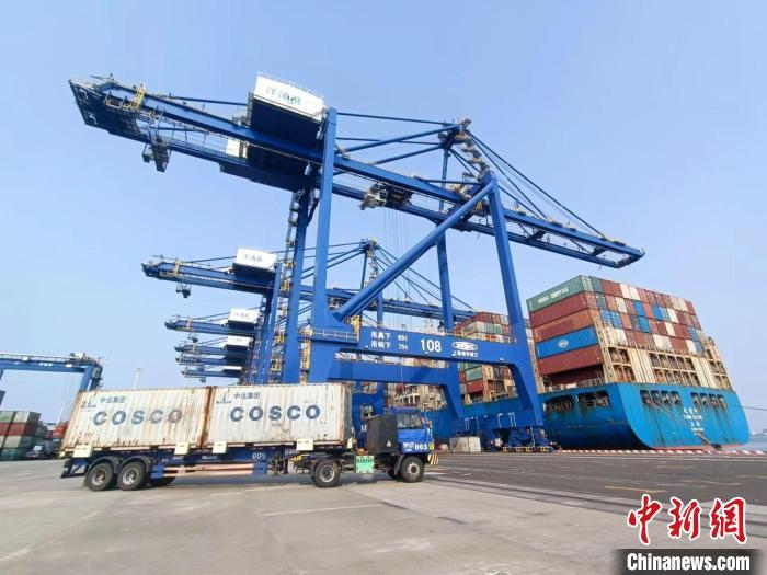 圖為海南洋浦國(guó)際集裝箱碼頭，卡車將集裝箱從后方堆場(chǎng)運(yùn)往碼頭裝卸區(qū)。　張?jiān)潞?攝