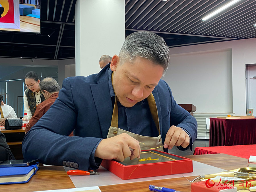 2023“一帶一路”媒體合作論壇聯(lián)合采訪團團員，親身體驗景泰藍工藝。人民網(wǎng)記者 于洋攝