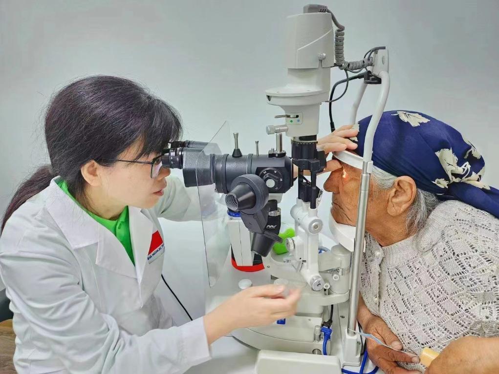 北京大學(xué)人民醫(yī)院眼科醫(yī)生鮑永珍正在為中亞白內(nèi)障患者進行眼部檢查。（北京大學(xué)人民醫(yī)院供圖）