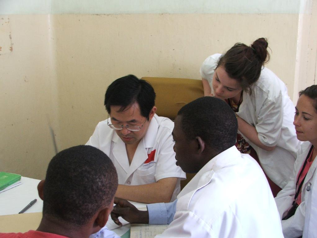 2011年7月22日，在坦桑尼亞桑給巴爾納茲莫加醫(yī)院外科門診，中國第24批援桑給巴爾醫(yī)療隊隊長盧建林為當(dāng)?shù)鼗颊咴\治并帶教實習(xí)生。新華社發(fā)（國家衛(wèi)生健康委供圖）