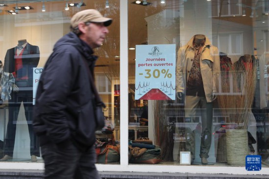   10月31日，一名男子從比利時(shí)布魯塞爾一家貼有打折信息的店鋪前走過(guò)。新華社記者 趙丁喆 攝