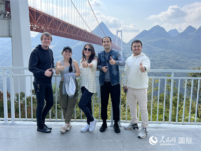 歐亞國家記者在壩陵河大橋下合影，并給大橋“點贊”。人民網 花放攝