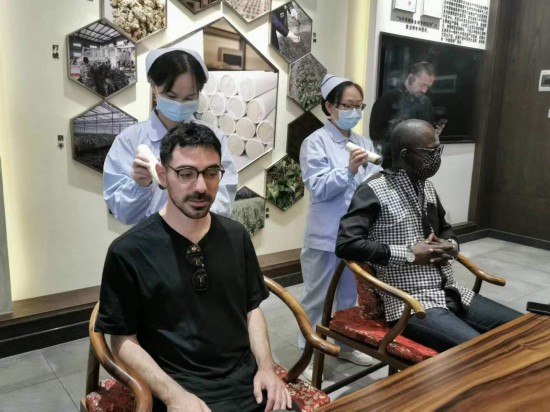 2023“一帶一路”媒體合作論壇聯(lián)合采訪團(tuán)團(tuán)員在九牛草展示館體驗(yàn)艾灸。（本報(bào)記者 黃超攝）