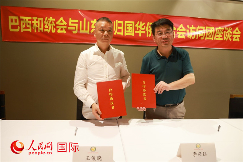 中國僑聯(lián)副主席、山東省僑聯(lián)主席李興鈺（右）與巴西和統(tǒng)會會長王俊曉簽署合作協(xié)議書。人民網(wǎng)記者 陳海琪攝