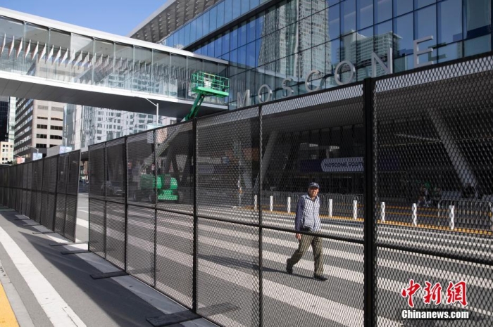 當(dāng)?shù)貢r(shí)間11月10日，一名行人從美國舊金山莫斯康中心周圍的金屬圍欄旁經(jīng)過。隨著亞太經(jīng)合組織(APEC)第三十次領(lǐng)導(dǎo)人非正式會(huì)議臨近，作為會(huì)議場地的莫斯康中心附近出現(xiàn)金屬圍欄，執(zhí)勤警察也大幅增加。<a target='_blank' href='/'><p  align=