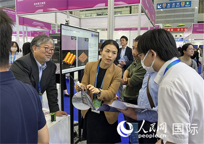 工作人員向參觀者介紹超級噴墨技術(shù)。（人民網(wǎng)記者 陳思攝）