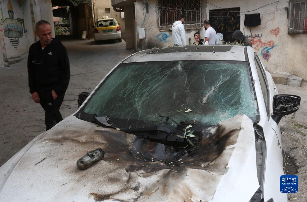 12月17日，在約旦河西岸城市圖勒凱爾姆附近的一處難民營，人們查看在沖突中損毀的車輛。新華社發(fā)（尼達爾·艾仕塔耶攝）