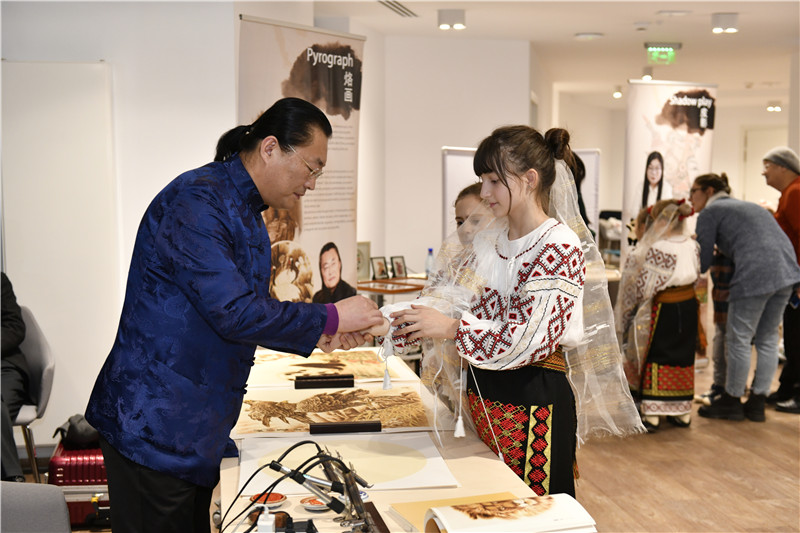 圖為羅馬尼亞小學(xué)生在現(xiàn)場體驗(yàn)烙畫。 布加勒斯特中國文化中心供圖