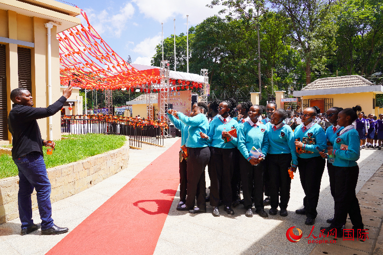 一名老師在給學(xué)生拍照留念。人民網(wǎng)記者 黃煒鑫攝