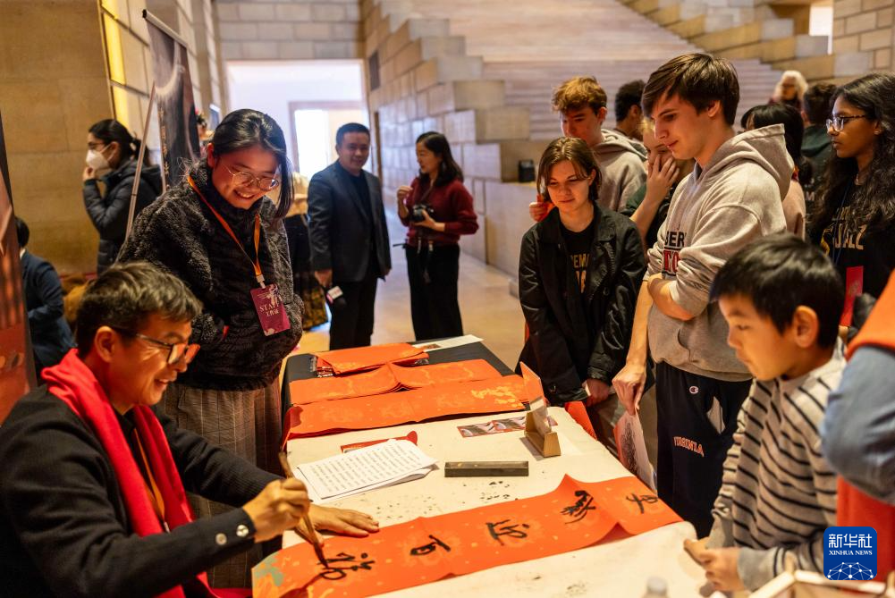 2月11日，書法家在美國費城藝術(shù)博物館舉行的龍年迎新春活動上為參觀者書寫對聯(lián)。新華社發(fā)（周煥新攝）