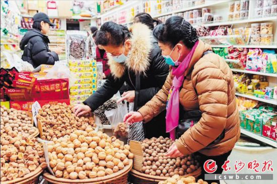 　　在長沙南門口菜市場附近的一家炒貨店內，市民正在選購年貨。　　長沙晚報全媒體記者 范宏歡 攝