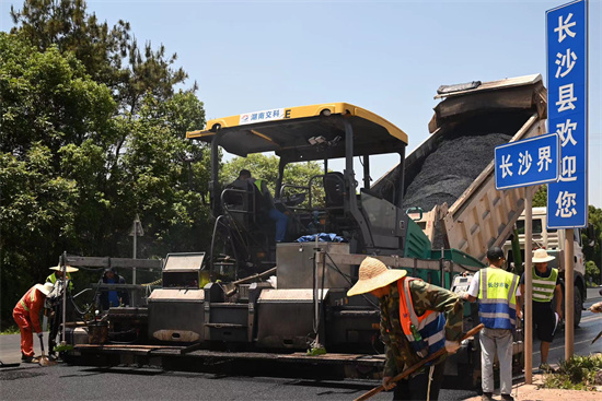 工人正在進行“極薄磨耗層”路面的鋪筑。受訪單位供圖