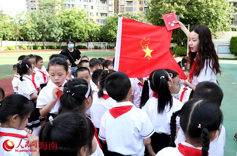 老師向少先隊員展示隊旗。人民網 符武平攝