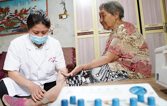 護理團隊醫(yī)生為老人進行低頻功能康復(fù)。陳佳兵攝