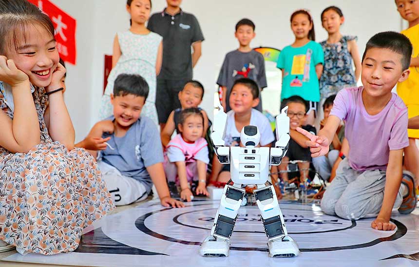 2022年7月19日，河北省秦皇島市海港區(qū)白塔嶺街道秦皇半島第二社區(qū)內(nèi)，小朋友正在觀看“機(jī)器人跳舞”。 曹建雄攝