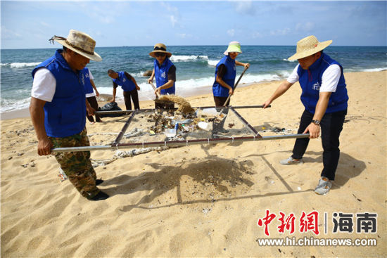 環(huán)保志愿者用篩網(wǎng)“淘”出海灘上的垃圾。