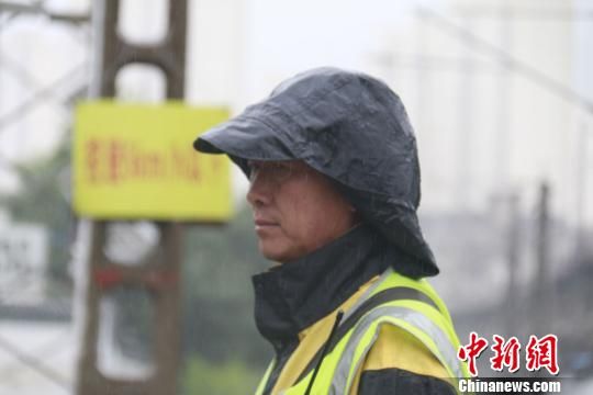 蘭州西工務(wù)段蘭州線路車(chē)間防護(hù)員雨中巡查?！⊥豕廨x 攝