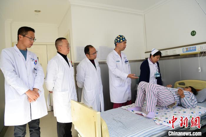 圖為何蔚副主任醫(yī)師(站右二)及團(tuán)隊(duì)術(shù)后指導(dǎo)患者進(jìn)行腰背肌鍛煉。　貢嘎來(lái)松 攝