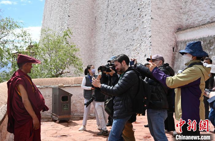 圖為中外媒體拍攝朝拜布達(dá)拉宮的僧人?！≮w朗 攝