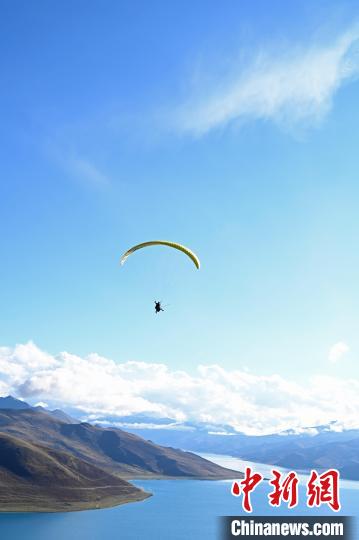 圖為在羊卓雍錯(cuò)，游客體驗(yàn)高空滑翔?！≮w朗 攝