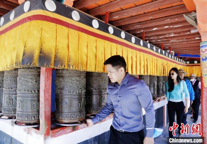 圖為外籍嘉賓體驗藏族傳統(tǒng)轉(zhuǎn)經(jīng)筒?！●R銘言 攝