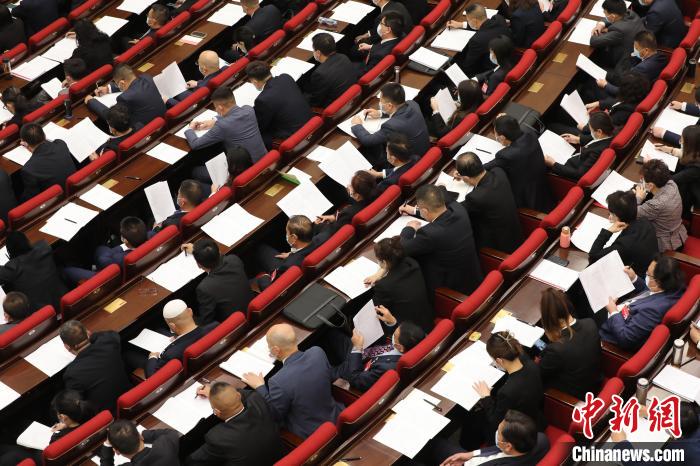 圖為會議現(xiàn)場，參會代表正在聽取政府工作報告?！∑钤鲚?攝