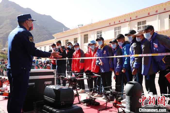 圖為消防指戰(zhàn)員為學生講解、演示先進救援裝備?！≮w琳 攝