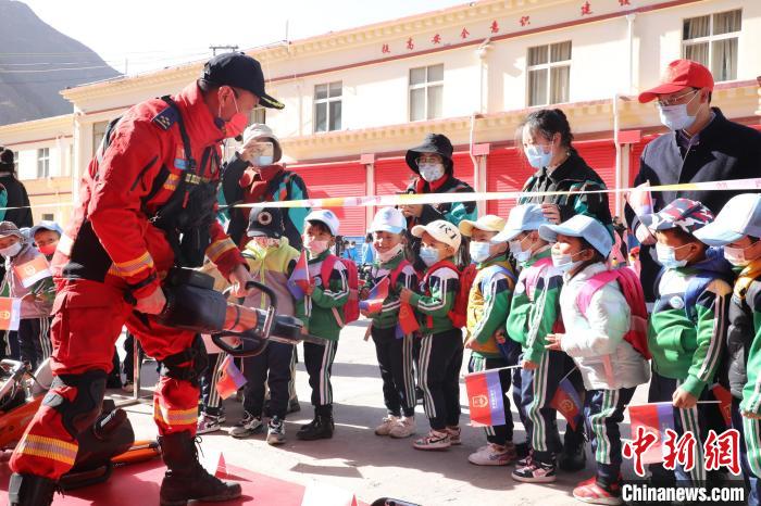 圖為消防指戰(zhàn)員為學生講解、演示先進救援裝備?！≮w琳 攝